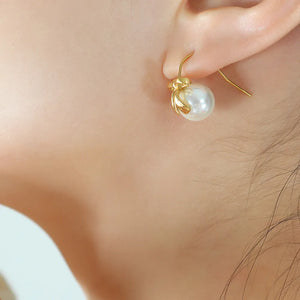 Gold pearl bow drop earrings with 18K gold plating.