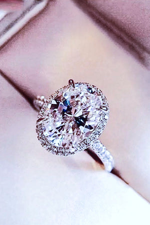 Halo oval diamond engagement ring in white gold with pave band.