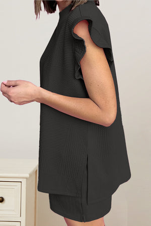 Black textured loungewear set with flutter sleeves and mock neck top with side slits.