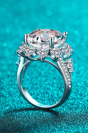 Silver moissanite cocktail ring with large center stone and heart-shaped accent stones.