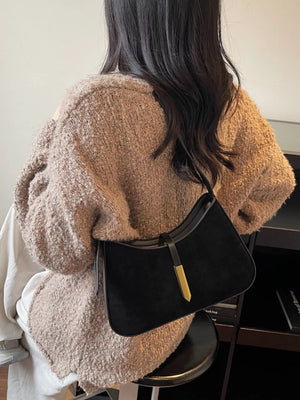 Black suede and leather shoulder bag with gold accent detail.