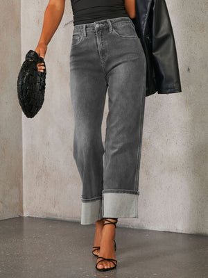 Dark wash denim jeans with cuffed hems and a wide-leg cut.