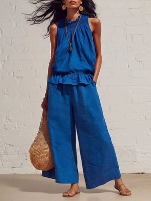 Blue smocked peplum top and flowing pants set with a ruffled hem and wide legs.