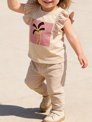 Baby girls' tan cotton tee with playful palm tree graphic and pink pom-pom ruffle sleeves.