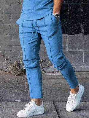 Light blue casual drawstring sweatpants with pockets and contrast stitching.