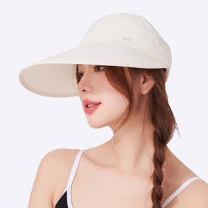 Beige wide brim sun visor hat with a subtle logo detail, worn by a woman.