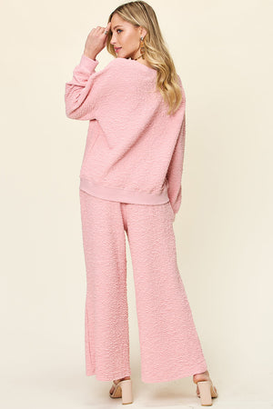 Textured lounge set in Dusty Pink, featuring a relaxed fit sweatshirt and wide leg pants.