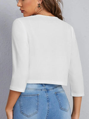 White cropped open-front blazer with elbow sleeves and a textured finish.