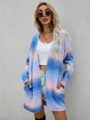 Longline knit cardigan with rainbow gradient in blue, pink, and blush, featuring pockets and an open front.
