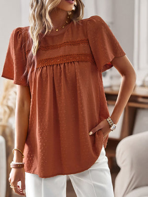 Textured puff sleeve yoke top in terracotta with lace detail and short sleeves.