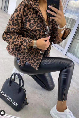 Leopard print denim jacket with frayed hem and buttoned pockets.