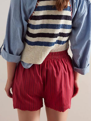 Scarlet boxer shorts with thin navy pinstripes and a scalloped hem.