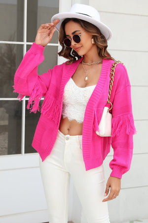 Hot Pink acrylic cardigan with fringe sleeves and open front, styled with a white lace cami and white jeans.