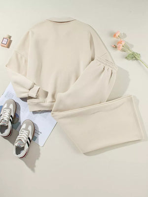 Beige cotton zip-up jacket and drawstring pants set with cuffed sleeves and elastic waistband.