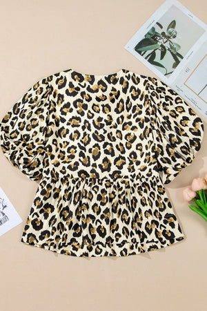 Leopard print peplum blouse with puff sleeves and tie-neck detail.