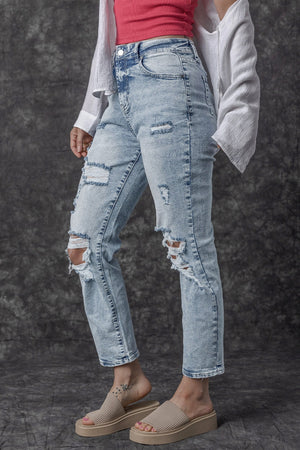 Distressed wash light denim slim leg jeans with ripped details
