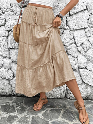 Tiered maxi skirt in tan with drawstring waist and ruffled tiers.