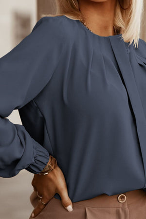 Misty Blue pleated yoke blouse with button detail and long sleeves.