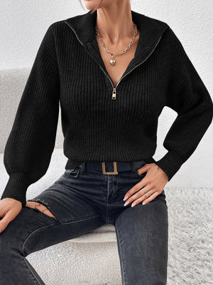 Black ribbed zip-up sweater with a high collar and balloon sleeves.
