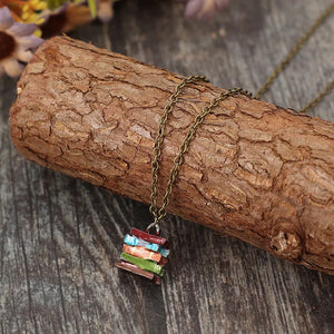 Stacked prism charm necklace with multicolor stacked book pendant on antique brass chain.