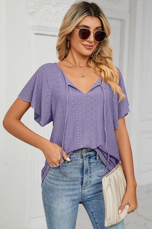 Lavender eyelet tie-neck blouse with flutter sleeves and v-neckline.
