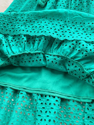 Green eyelet tiered maxi skirt with cutout details and a tassel drawstring.