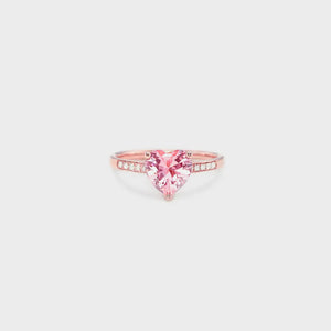 Rose gold ring with a pink heart-cut pavé stone and diamond accents.