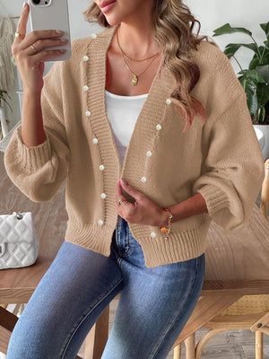 Tan bubble sleeve cardigan with pearl buttons and V-neck, styled with a white tank and jeans.