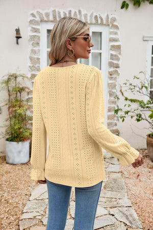 Eyelet lace blouse in light yellow with ruffle sleeves and a textured pattern.