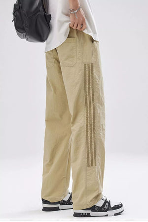 Men's khaki wide-leg cargo pants with decorative side stripe detail and front pockets.