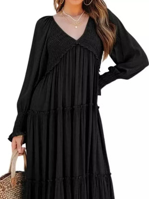 Black smocked V-neck tiered maxi dress with long sleeves and ruffled tiers.