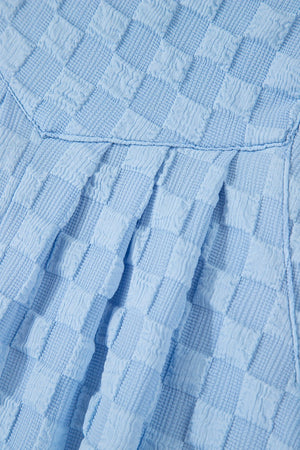 Light blue textured checkered button-strap palazzo jumpsuit detail