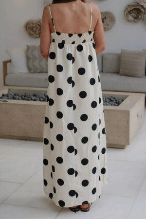 Cream polka dot maxi dress with smocked bodice and spaghetti straps.