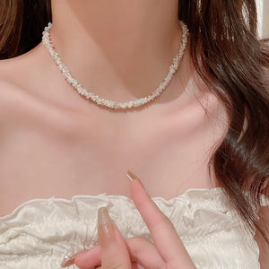 Pastel petal chain necklace with delicate beads in pink and purple hues.