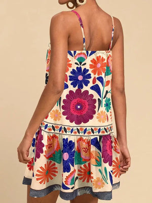 Vibrant floral print mini dress with spaghetti straps and tiered skirt.