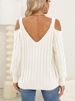 Ivory cable knit cold shoulder sweater with V-neck and balloon sleeves.
