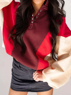 Color block cotton hoodie with button neckline in red, brown, and cream.
