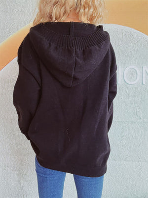Black chunky knit hooded cardigan with ribbed neckline detail.