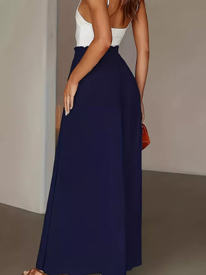 Dark blue wide-leg trousers with paperbag waist, flowing silhouette, styled with a white camisole.