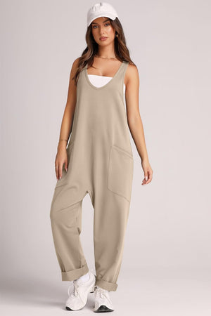 Khaki relaxed fit jumpsuit with v-neck, oversized pockets, and cuffed hems.
