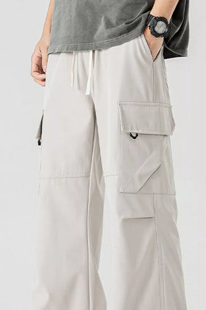 Men's beige cargo pants with multiple pockets and drawstring waist.