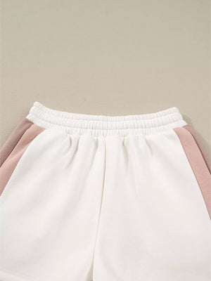 White cotton shorts with blush pink color block detail and elastic waistband.