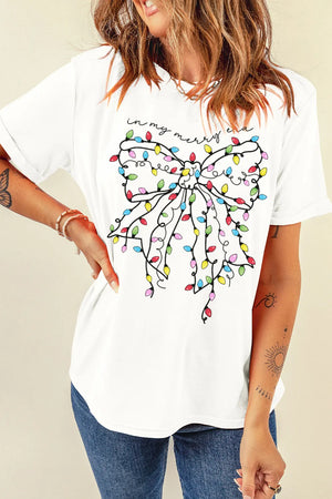 White t-shirt with a colorful holiday light bow graphic and "in my merry era" text.