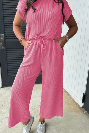 Ribbed knit drawstring co-ord set in fuchsia pink with cropped wide-leg pants and short sleeves.
