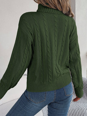 Dark green cable knit turtleneck sweater with voluminous sleeves.