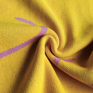 Banana yellow knit midi dress with pink swirl print and halter neckline detail.