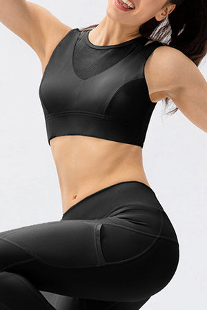 Black mesh inset performance bra top with V-neck detail and athletic cut.