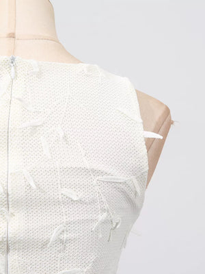 White midi dress with floral applique and boat neck, showing back zipper detail.