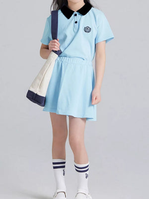 Light blue cotton polo skort ensemble for kids with black collar and embroidered crest.