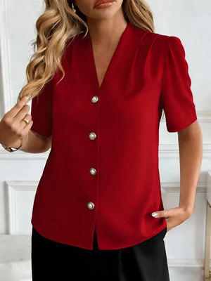 Burgundy V-neck short sleeve shirt with pearl button details and puff sleeves.